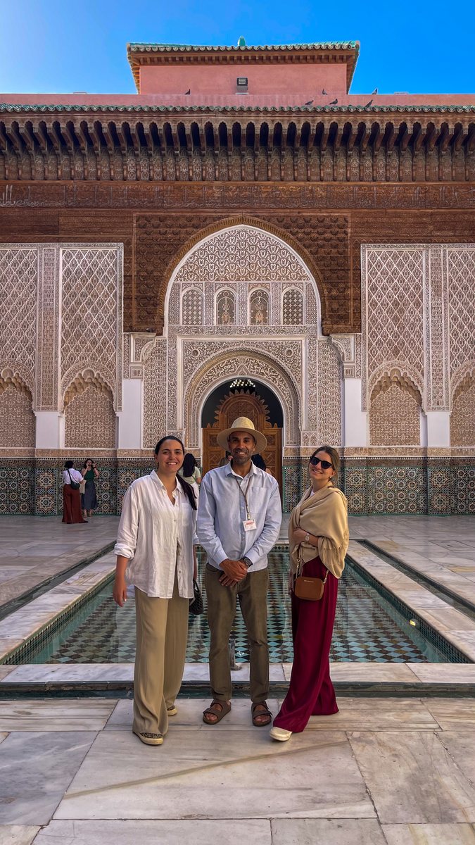 Travelers posing in front of Moroccan palace architecture